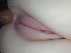 Close up of a cute Japanese teen’s oily body during anal sex with a toy.