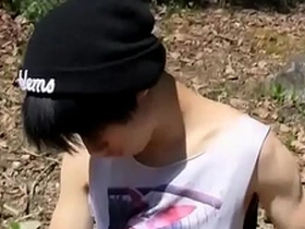 A small and pretty Asian boy pleasuring himself with anal beads outdoors.